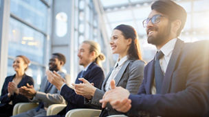 Contemporary business people clapping their hands at conference or other corporate event