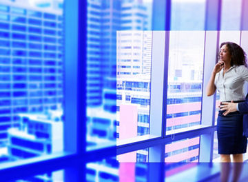 Lady and man discussing against office window