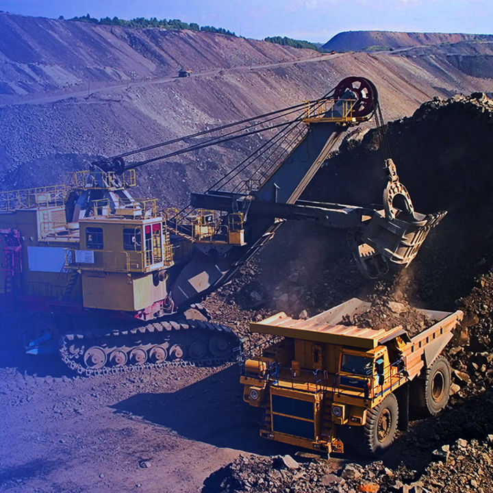 Large excavator loading rock into mining truck