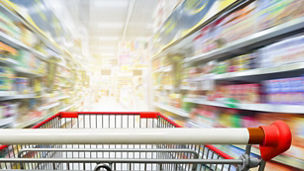 Supermarket aisle with empty red shopping cart