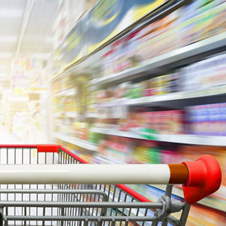 Supermarket aisle with empty red shopping cart