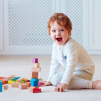Smiling baby playing with blocks