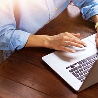 Young beautiful woman working with a laptop. Female freelancer connecting to internet via computer. Blogger or journalist writing new article.