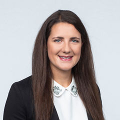 Porträt von Lena Kogler vor einer hellgrauen Wand