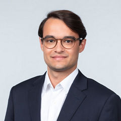 Porträt von Leon Schaller vor einer hellgrauen Wand