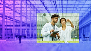 Two people looking at a tube in a lab