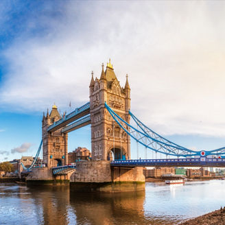 Panoramic London skyline with iconic symbol, the Tower Bridge and Her Majesty's Royal Palace and Fortress, known as the Tower of London as viewed from South Bank of the River Thames in the morning light