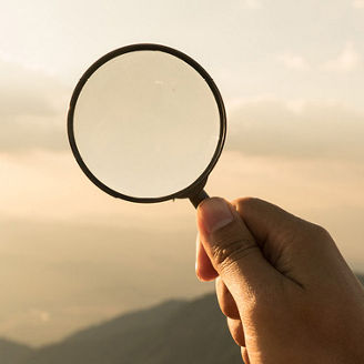 Magnifiying glass at mountain sky