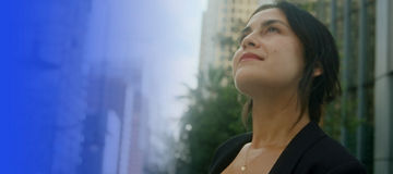 Woman in city looking up banner