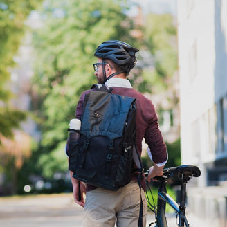 Male commuter or messenger with a bike in urban background. Safe cycling in the city, going to work by bicycle, delivery man image