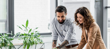 smiling virtual reality architects looking at laptop in office
