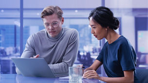 man and woman looking at the laptop banner