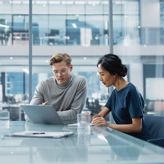 man and woman looking at the computer