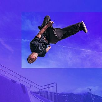 Young Parkour and Freerunning athlet doing a backflip from a wall in an urban enviroment with a blue sky in de background, jumping tumbling  Gymnastics training concept
