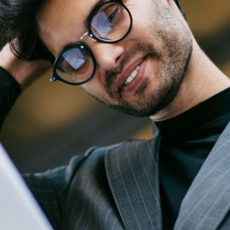man en vrouw met laptop kijkend naar een groot scherm