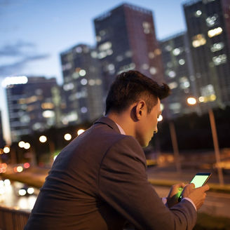 Man in a suit looking at his phone