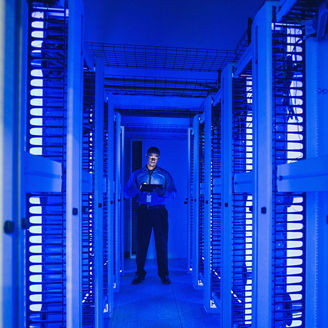 Man in blauwer serverroom met tablet in hand