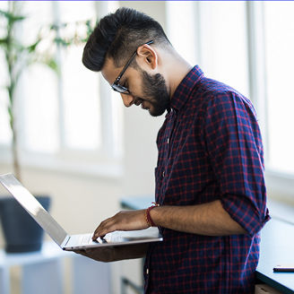 Man in spectacles checking laptop