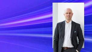 Man in suit posing with blue gradient banner