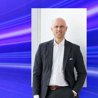 Man in suit posing with blue gradient banner