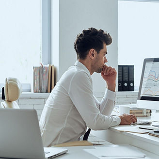 Man looking at statistical graphs on computer screen