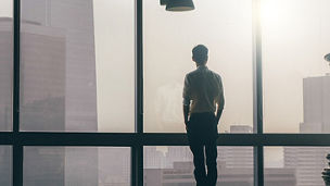 Man looking out from skyscraper window