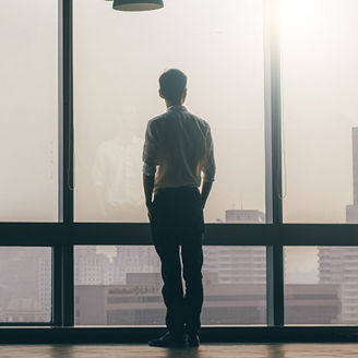 Man looking out from skyscraper window