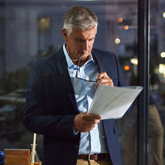 Business professional reviewing documents in a modern office at night.