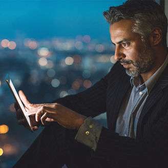 Man sitting at window using tablet