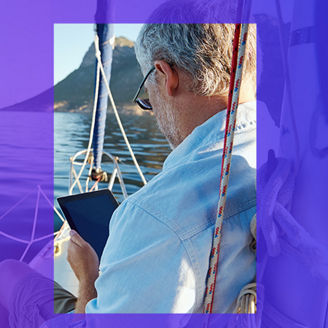 Man sitting in yatch looking at tablet banner