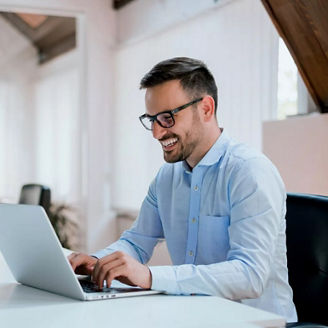man smiling and working on laptop