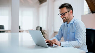 Man smiling and working on laptop