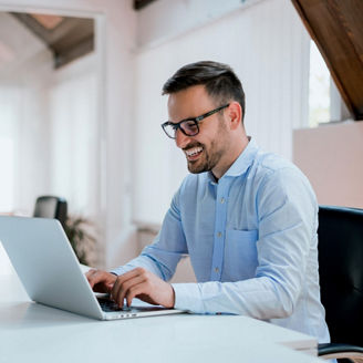 Man smiling and working on laptop