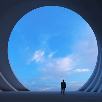 Man walking through a large exit in a modern building towards the light at the end of the tunnel
