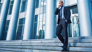 A man taking over cellphone standing outside office
