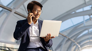 man talking on phone seeing laptop 