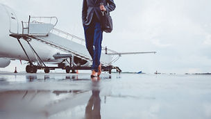 Man walking on runway with private jet in background