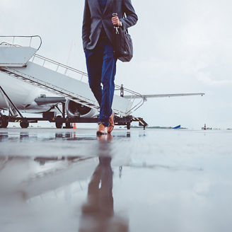 Man walking on runway with private jet in background