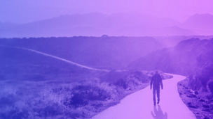 Man walking on the road between mountains