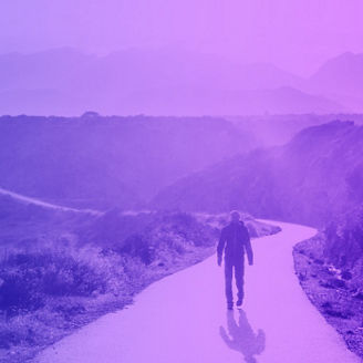 Man walking on the road between mountains