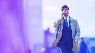 Outdoor shot of young woman using mobile phone outdoors in the city. Female business professional using smart phone in the city.