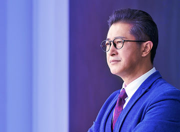 Man wearing spectacles and holding cup