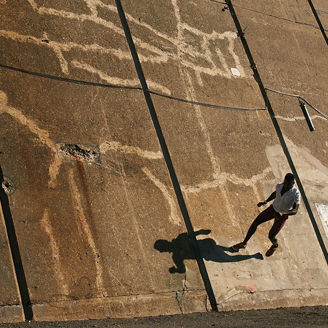Man wearing white shirt running on inclined cemented path