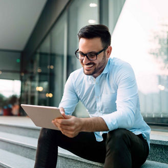 Happy and confident businessman using tablet on office stairs