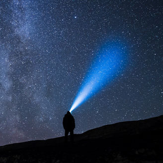 Man with torch looking at the stars, milky way, night sky
