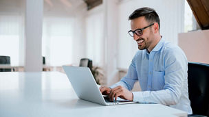 Portrait of young man sitting at his desk in the office