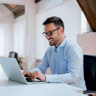 Portrait of young man sitting at his desk in the office