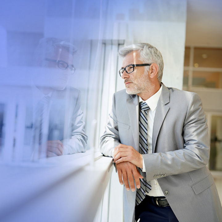 man in suit looks out of window