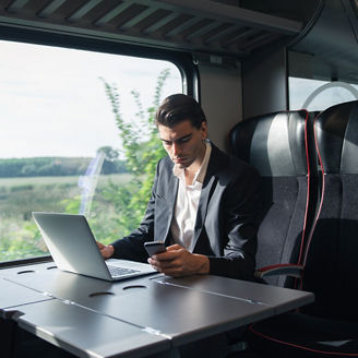 Mann im Zug am Laptop