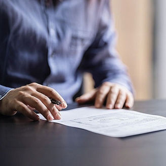 A man is sitting in front of a sheet of paper